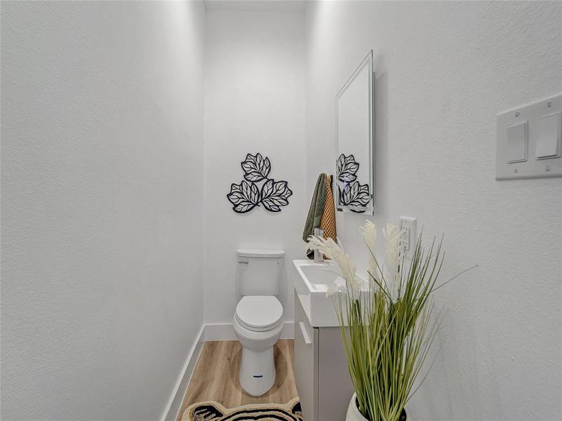 Bathroom featuring toilet, hardwood / wood-style floors, and vanity