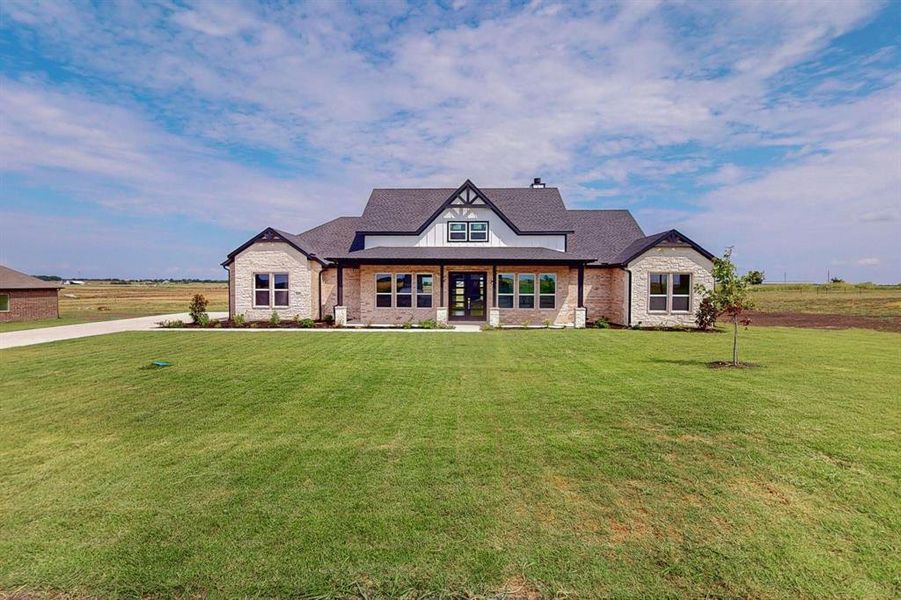 View of front of home featuring a front lawn and a rural view