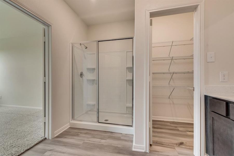 Bathroom with vanity, a shower with door, and hardwood / wood-style floors