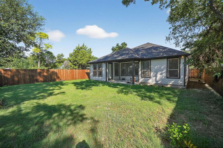 Back of house with a fenced backyard and a patio area