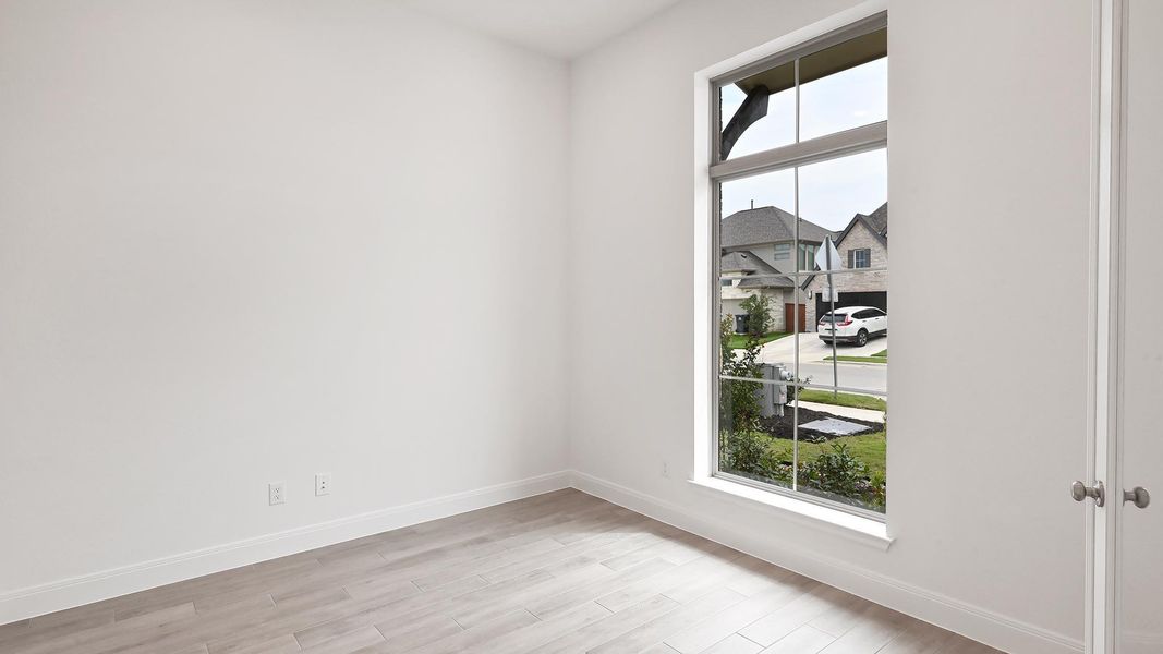 Unfurnished room with light wood finished floors and baseboards