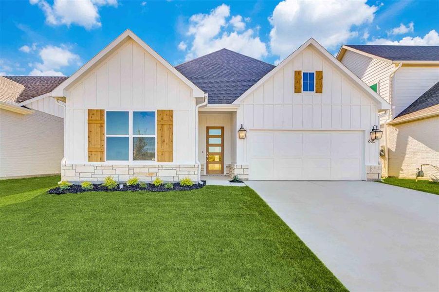 View of front of home featuring a front yard and a garage