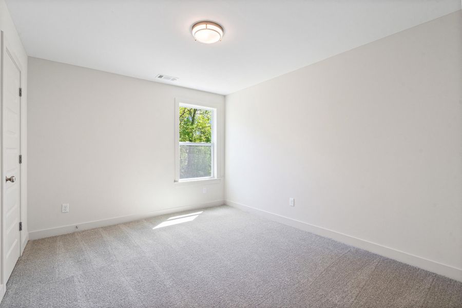 Unfurnished bedroom featuring light carpet and baseboards