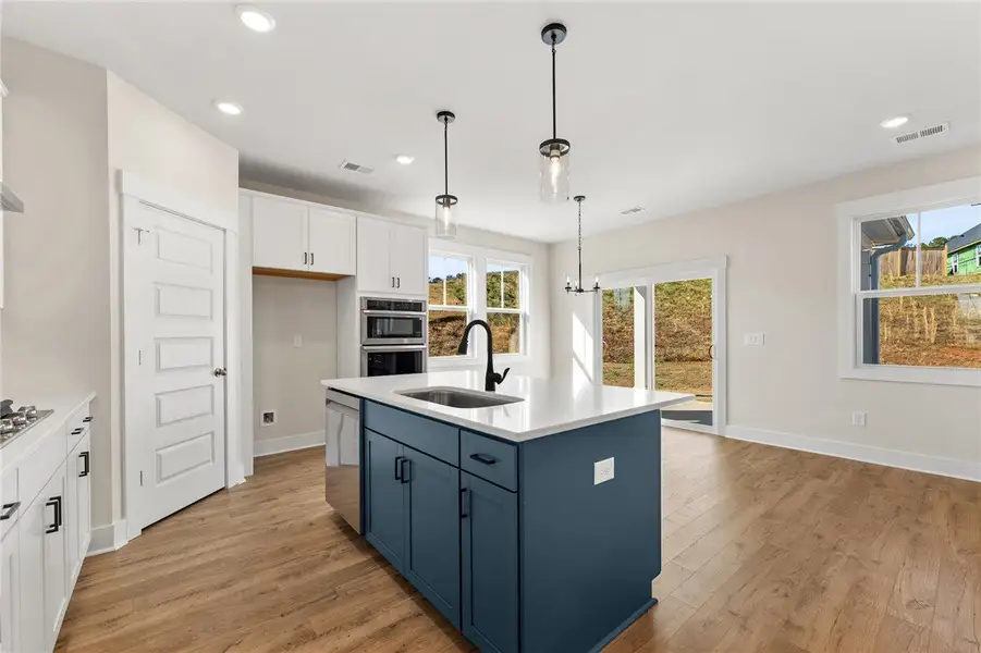 This luminous kitchen features an island, modern a