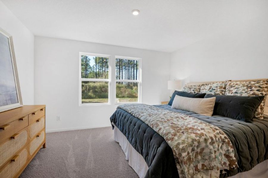 A bedroom with a bed and a window.