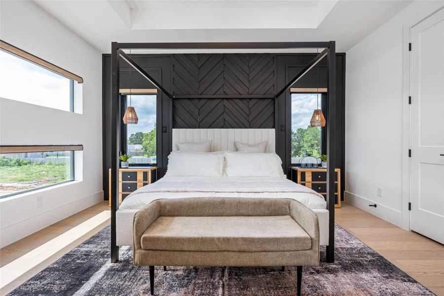 The primary suite is expansive and inviting with optional wood paneling, tray ceiling, designer fan, and an abundance of natural light—your dream retreat The primary suite is expansive and inviting with optional wood paneling, tray ceiling, designer fan, and an abundance of natural light—your dream retreat