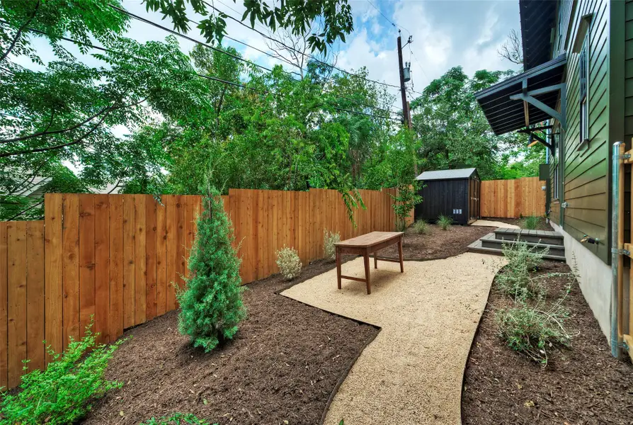 A well-maintained yard provides a private oasis, complete with a gravel pathway and dedicated seating area.