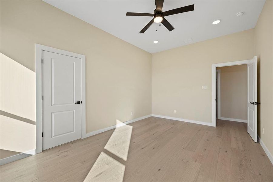 Empty room with light hardwood / wood-style flooring and ceiling fan