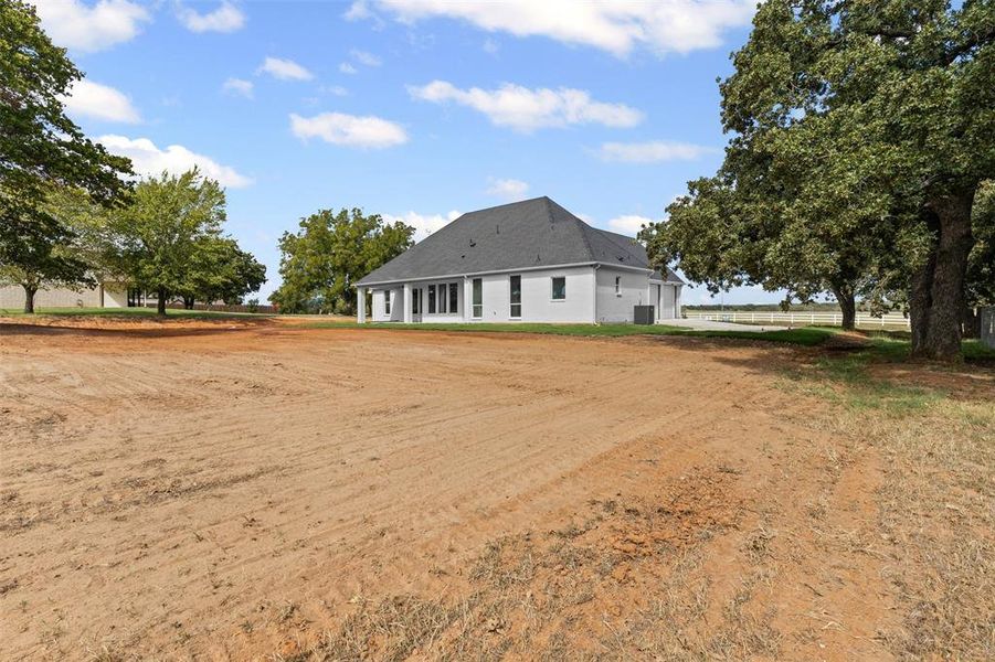 Rear view of property featuring dirt driveway