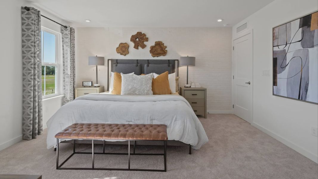 Carpeted primary suite with large window in a DRB Home Clementine model at the Trinity Place community.