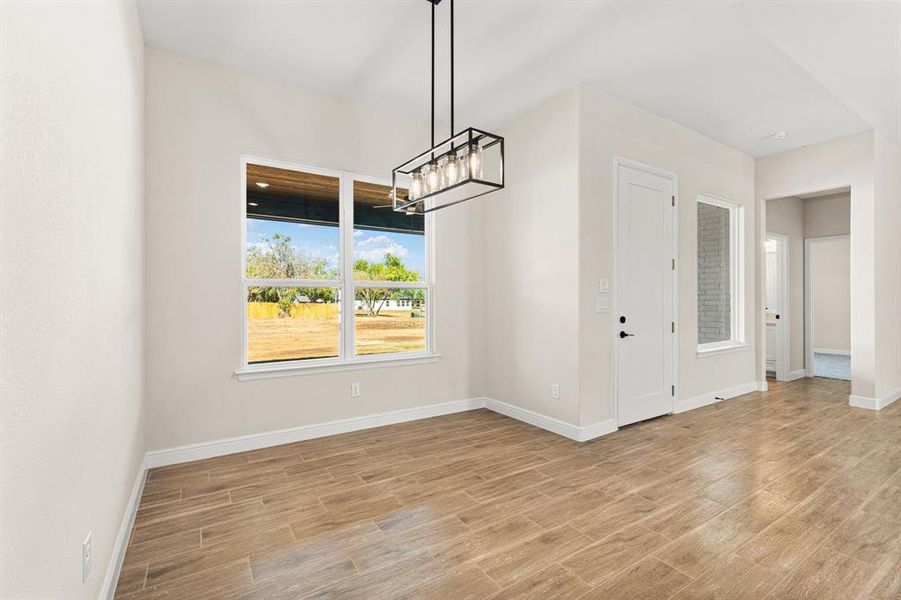 Unfurnished dining area with a chandelier and light wood finished floors
