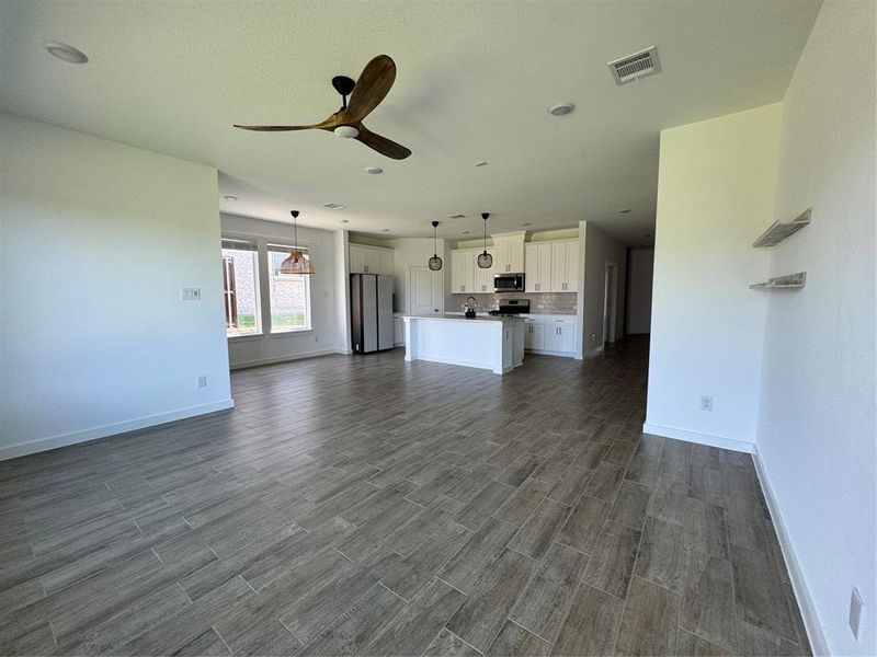 Living room featuring a ceiling fan and dark wood-style floors Living room featuring a ceiling fan and dark wood-style floors