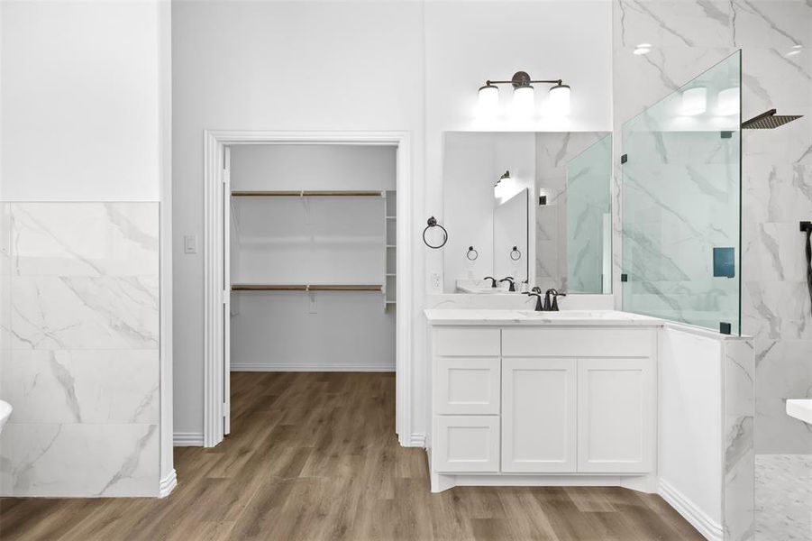 Bathroom with vanity, wood-type flooring, and tiled shower