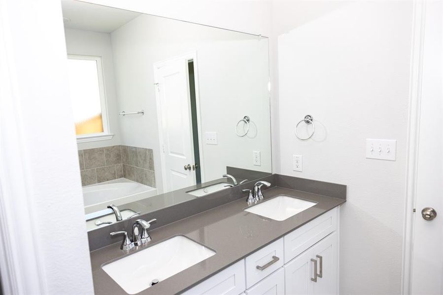 Full bath featuring double vanity and a garden tub Full bath featuring double vanity and a garden tub