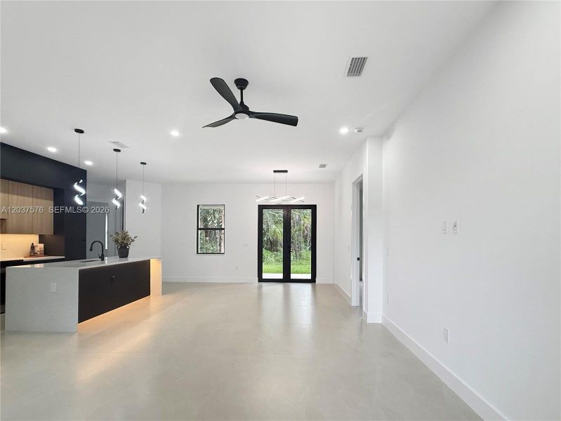 Open-concept living space featuring light-toned flooring and white walls