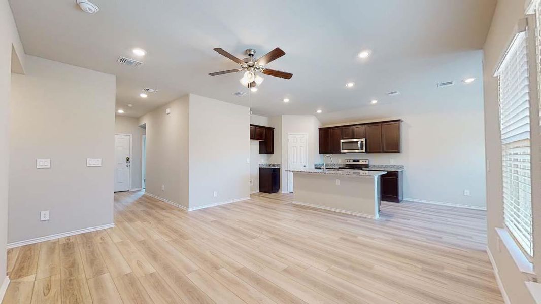 Open-concept living space with light wood-finish flooring