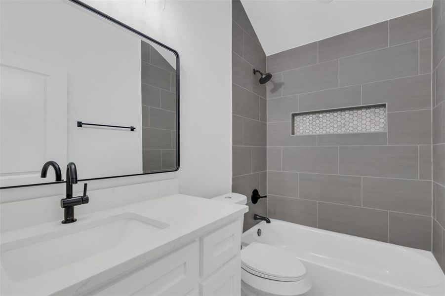 Bathroom with sleek quartz countertops and shower-tub combination