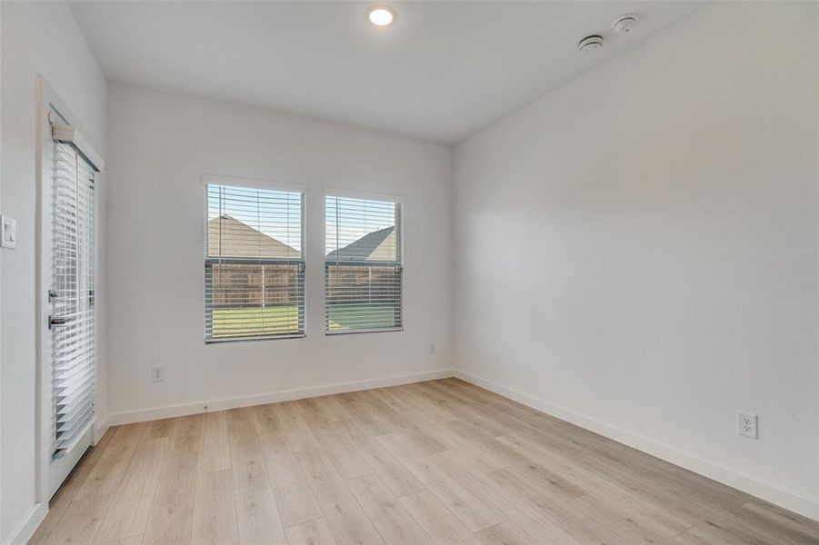Spare room featuring light wood-style floors and baseboards Spare room featuring light wood-style floors and baseboards