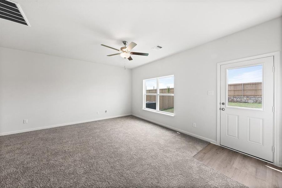 Carpeted empty room featuring ceiling fan