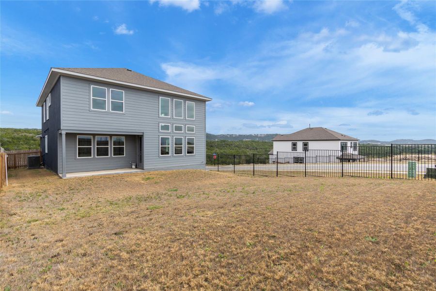 A contemporary residence with ample windows offers hillside views, blending modern design with a scenic backdrop.
