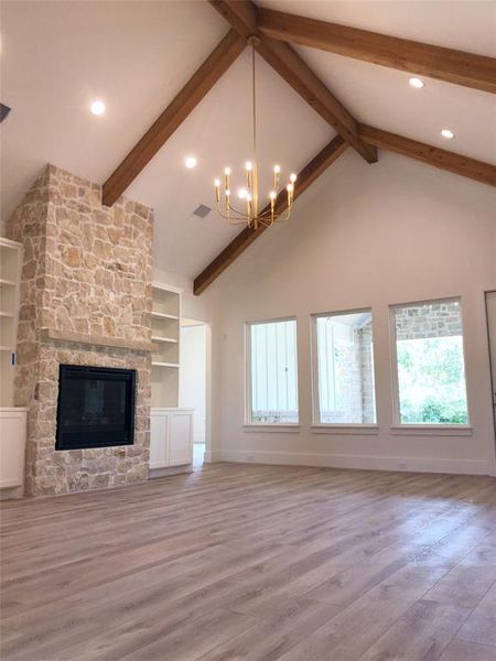 The spacious living area boasts a magnificent stone fireplace with gas logs, creating a warm and inviting atmosphere perfect for cozy evenings. Custom built-ins provide both functionality and style, seamlessly integrating with the home's design.