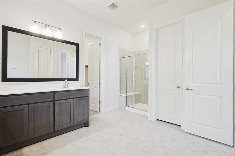 Bathroom featuring vanity and a shower with door