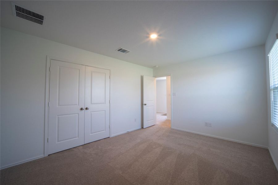 Unfurnished bedroom with carpet flooring and a closet