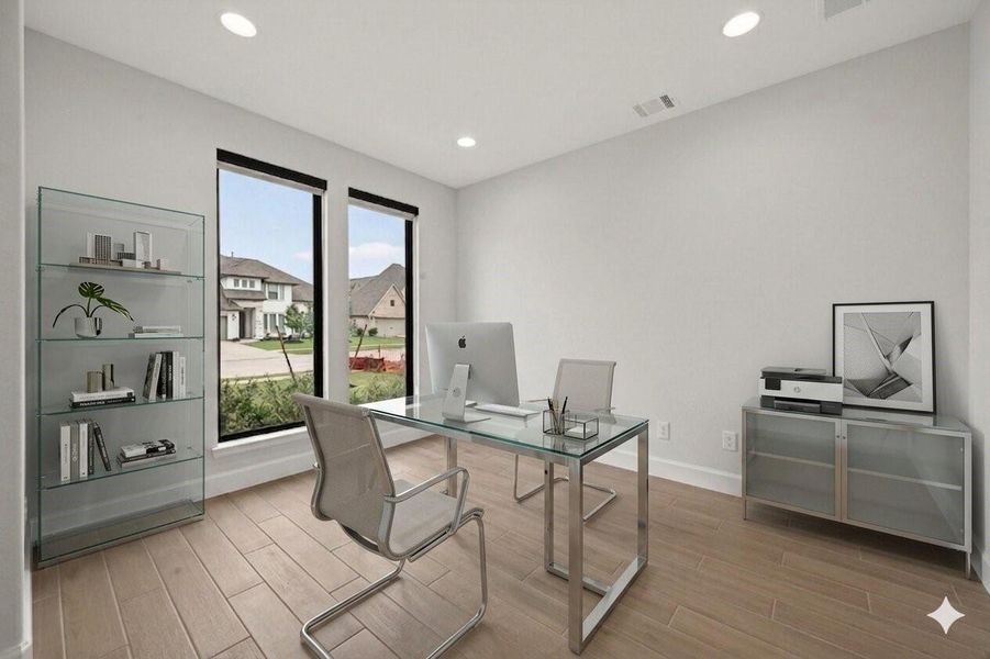 This photo shows a modern, minimalist home office with large windows offering natural light. It features a sleek glass desk, a contemporary chair, and a glass shelving unit. The neutral color palette and clean lines create a bright and inviting workspace.