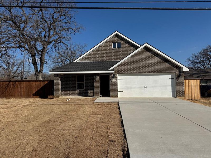 View of front of house with driveway, brick siding, an attached garage, and a shingled roof View of front of house with driveway, brick siding, an attached garage, and a shingled roof