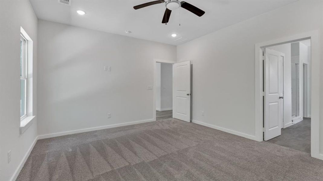 Unfurnished bedroom with ceiling fan and carpet flooring