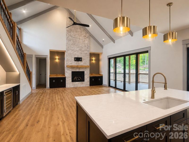 Vaulted great room with floor-to-ceiling stone fireplace and expansive sliding glass doors