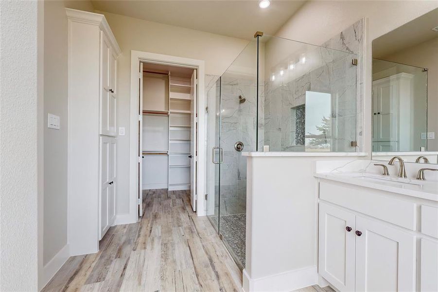 Bathroom featuring vanity, a shower with shower door, and wood-type flooring