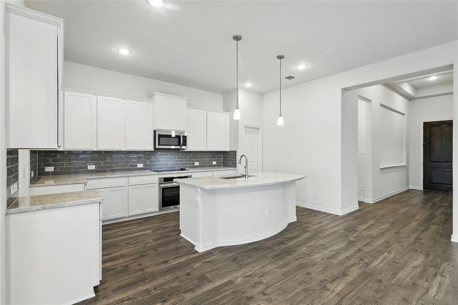 Kitchen featuring a sink, appliances with stainless steel finishes, backsplash, and white cabinets Kitchen featuring a sink, appliances with stainless steel finishes, backsplash, and white cabinets