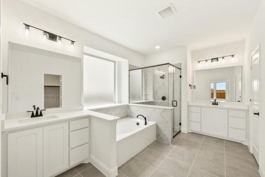 Master bathroom with dual vanities, soaking tub, glass walk-in shower, and tile floors Master bathroom with dual vanities, soaking tub, glass walk-in shower, and tile floors