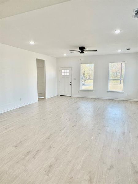 Unfurnished living room featuring recessed lighting, light wood finished floors, healthy amount of natural light, and a ceiling fan