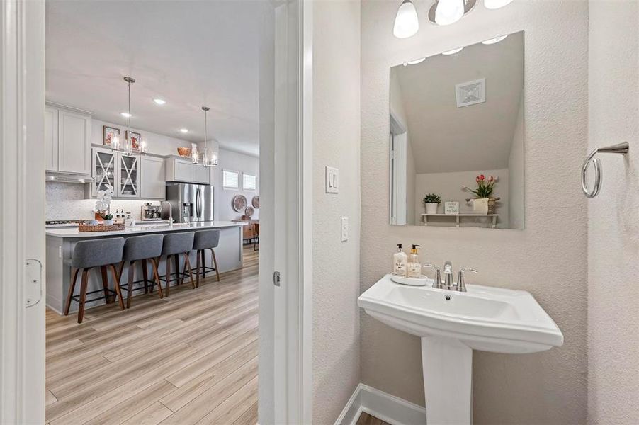 Bathroom featuring wood finished floors, recessed lighting, and a textured wall Bathroom featuring wood finished floors, recessed lighting, and a textured wall