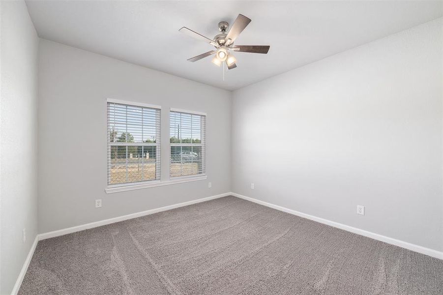 Empty room featuring ceiling fan and carpet