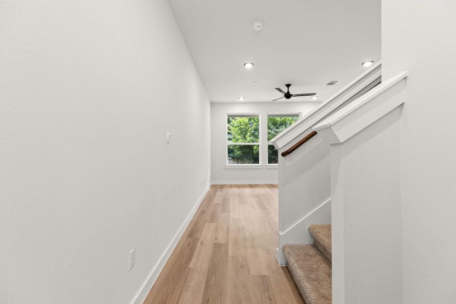 A well-lit area with high ceilings, recessed lighting, and a modern ceiling fan. A well-lit area with high ceilings, recessed lighting, and a modern ceiling fan.