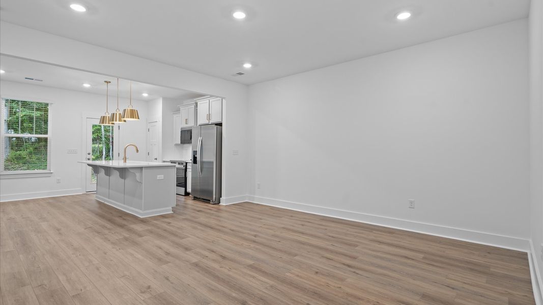 Spacious family room with rich hardwood flooring and elegant trim work in a reputable DRB Homes build Spacious family room with rich hardwood flooring and elegant trim work in a reputable DRB Homes build