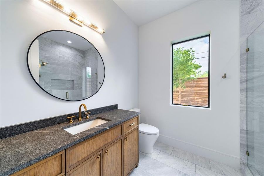 Bathroom with vanity, a shower stall, and light marble finish floors