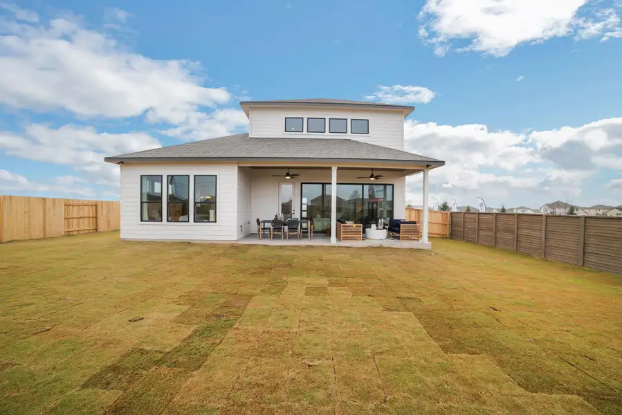 Rear view of house featuring a ceiling fan, an outdoor living space, a fenced backyard, and a patio area