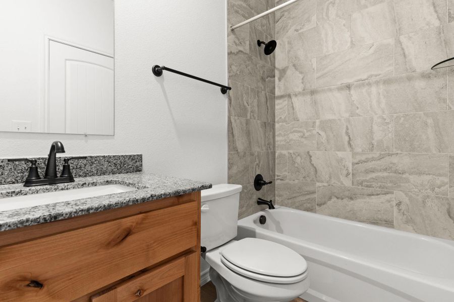 Full bathroom with toilet, vanity, and shower / bathtub combination Full bathroom with toilet, vanity, and shower / bathtub combination