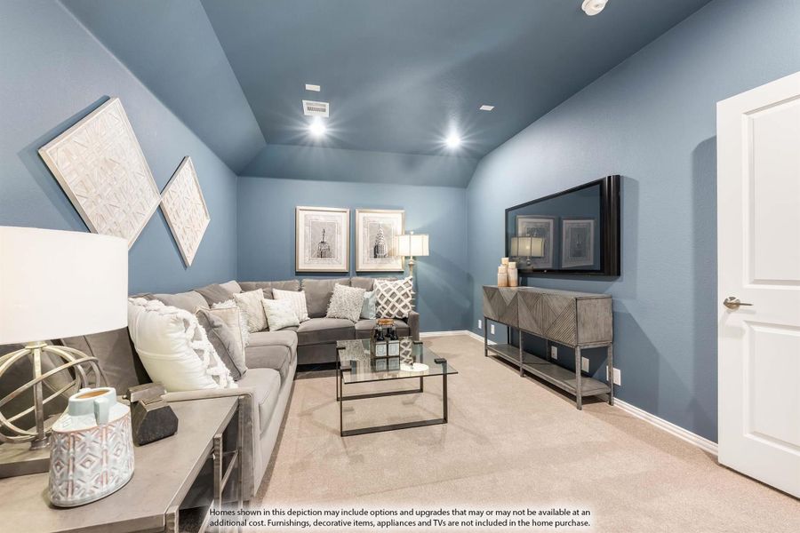 Living room with blue walls, vaulted ceiling, gray sectional sofa, and wall-mounted TV