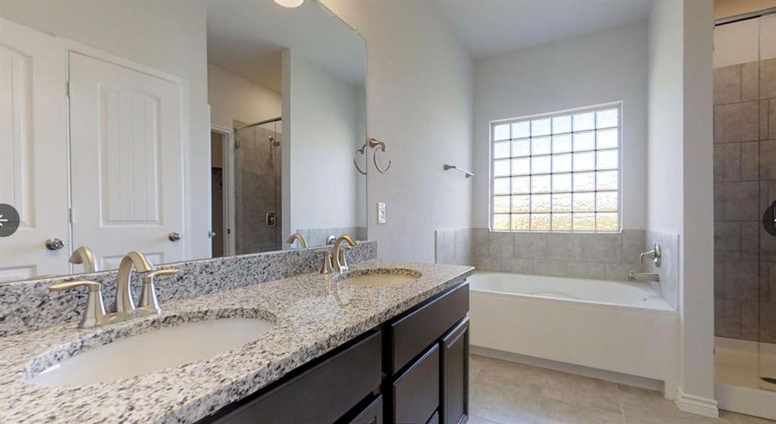 Bathroom with a shower stall, a bath, tile patterned flooring, and double vanity