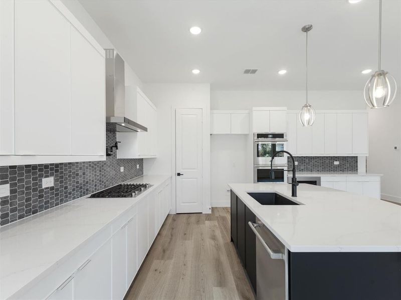 Kitchen with white cabinetry, backsplash, light stone counters, hanging light fixtures, and recessed lighting