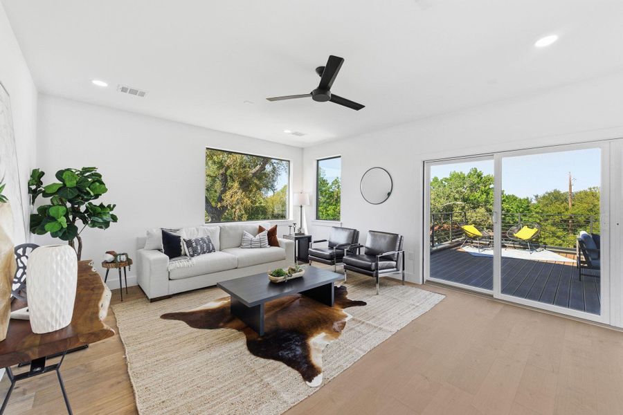 Flex space area off of upstairs bedrooms with private deck and tree top views  light wood-style floors, a ceiling fan, recessed lighting and dry bar