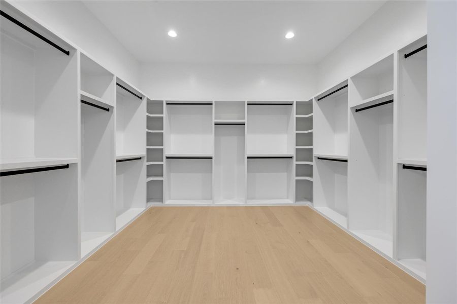 Walk in closet with light wood-style floors