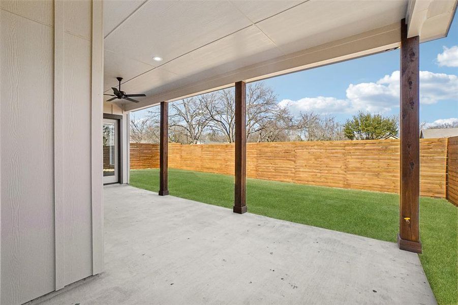 Fenced backyard featuring ceiling fan and a patio