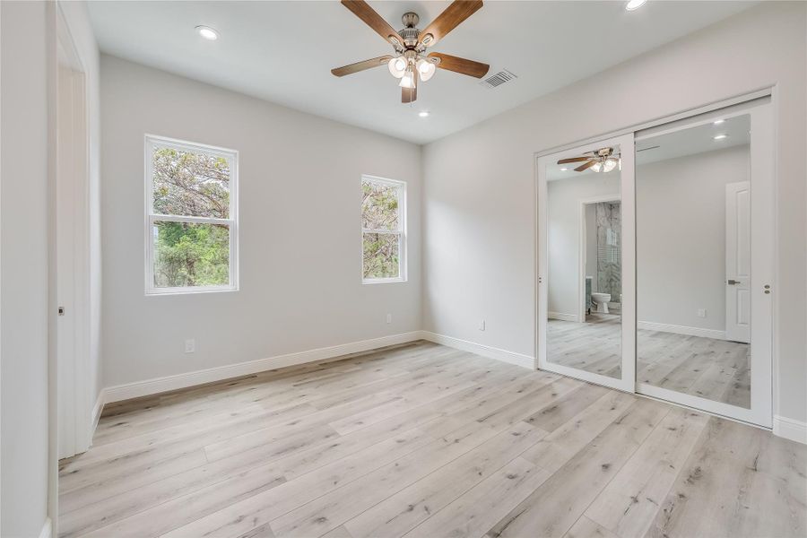 Unfurnished bedroom with ceiling fan, a closet, and light hardwood / wood-style flooring