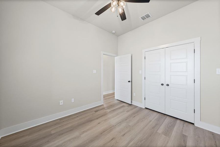 Unfurnished bedroom with light wood-type flooring, a ceiling fan, and a closet